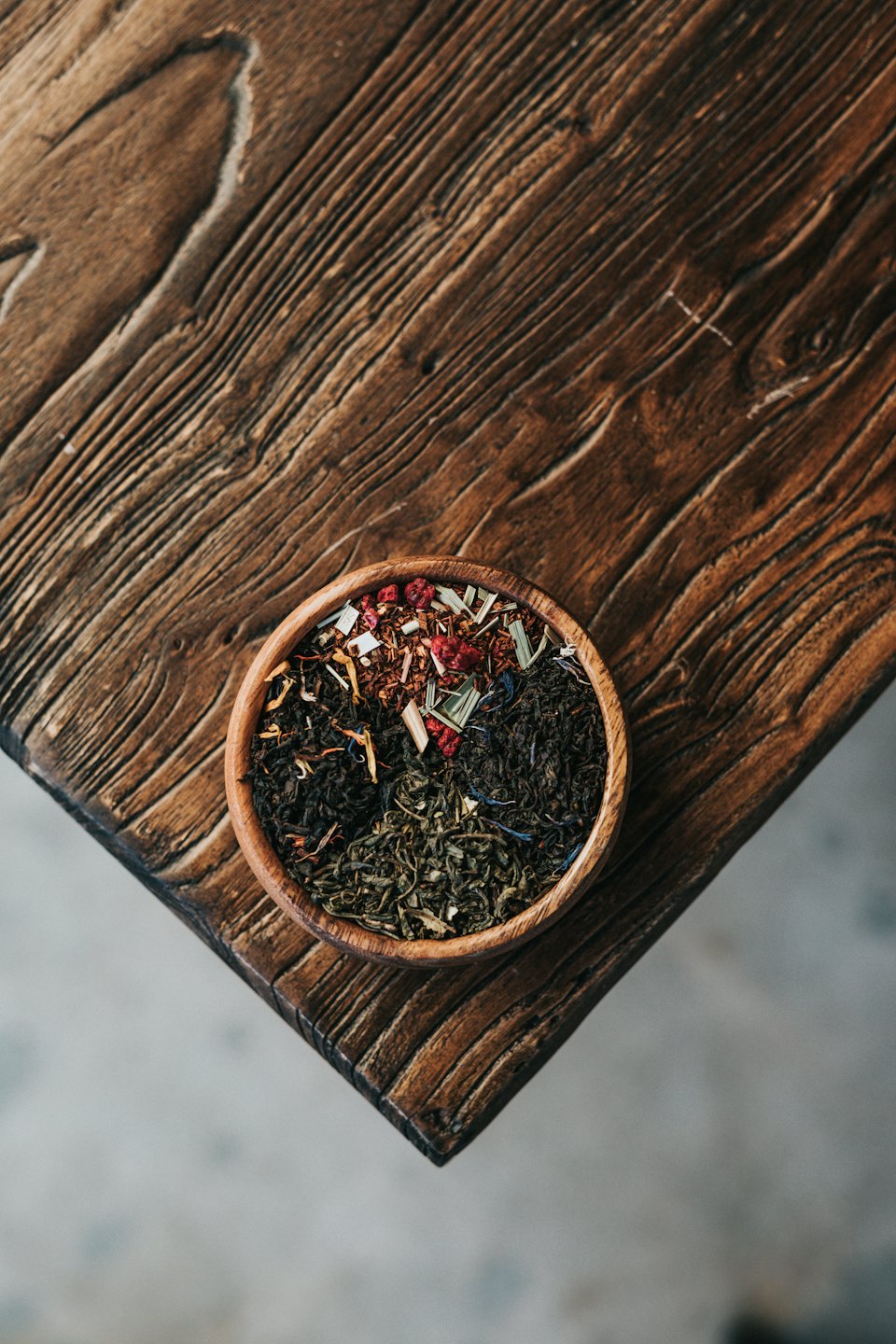 Rusty bowl with green, black, and herbal loose-leaf teas.